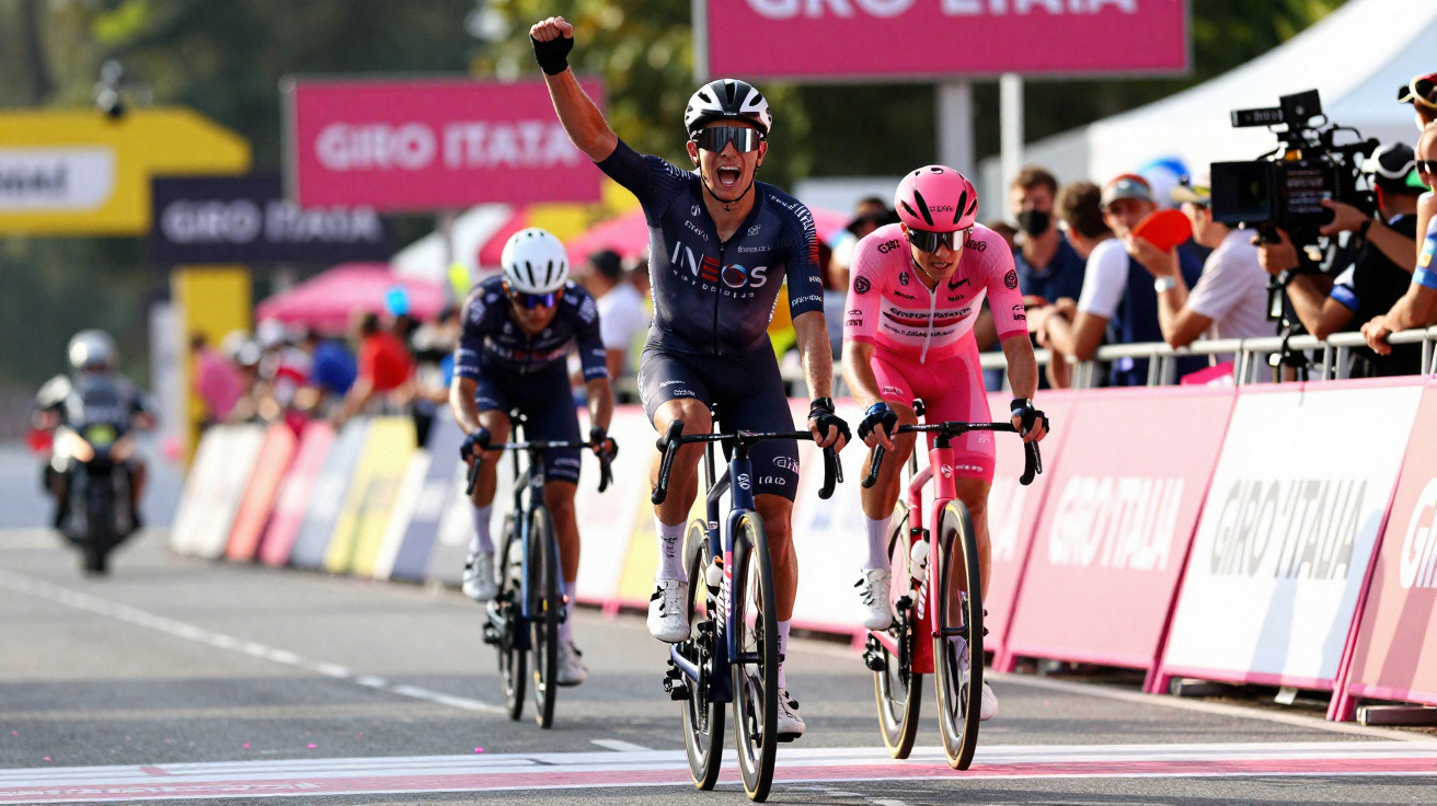 Ciclista da equipa INEOS comemora vitória na linha de chegada do Giro d'Italia rodeado por adversários e espectadores.